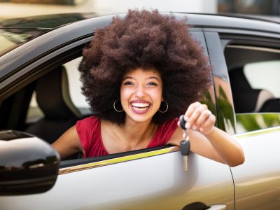 A smiling woman holding car keys, symbolizing a successful sale through Vidifye